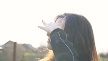 Güneş ışığı, gülümseyen genç kadın. Güneş portresi yaz günbatımı. Güzel açık hava.