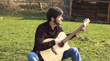 Eşcinsel ler dışarıda gitar çalıyor. Akustik gitarda müzik çalmak.