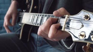 Müzisyen stüdyoda gitar çalar. Müzisyen yeni şarkısını kaydediyor. Adam gitar çalıyor.