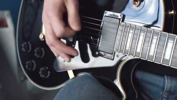 音楽家はスタジオでギターを演奏する ミュージシャンは彼の新曲を録音している 男はギターを弾いている — ストック動画