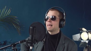 Müzisyen stüdyoda gitar çalar. Müzisyen yeni şarkısını kaydediyor. Adam gitar çalıyor.