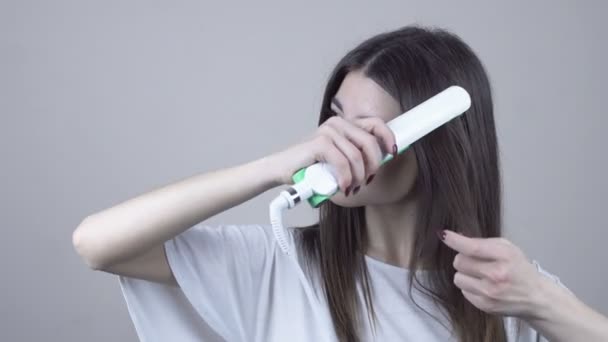 Mujer con hermoso pelo largo y liso usando plancha de pelo. Planchado de cabello — Vídeo de stock