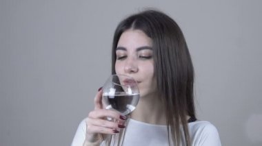Şarap kadehi tutan genç kız. Kapatın. Gri arkaplan