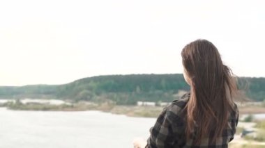 Güzel esmer kız eski bir analog kamerayla fotoğraf çekiyor, yürüyor ve çekim yapıyor.