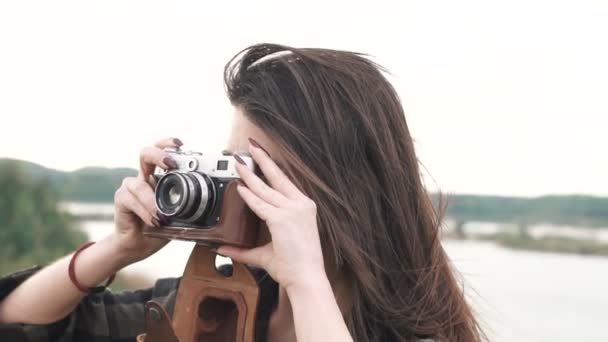 Krásná brunetka dívka dělá fotografie, natáčení se starou analogovou kamerou — Stock video