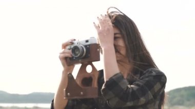 Güzel esmer kız, fotografi çekiyor, eski bir analog kamerayla tişört çekimi yapıyor. Yavaş çekim.