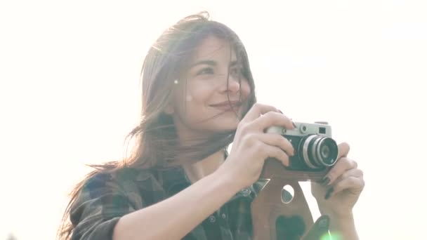 Krásná dívka dělá fotografie, na sobě tričko natáčení se starým fotoaparátem — Stock video