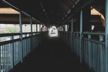 Üstgeçitte güneş ışığı ve gölgeyle yürüyoruz.