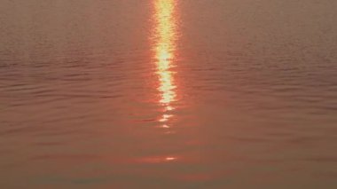 Su yüzeyi. Yansıtıcı su yüzeyine dalgalar ve dalgalarla yakından bakın. Doğal arkaplan ve gün batımı.