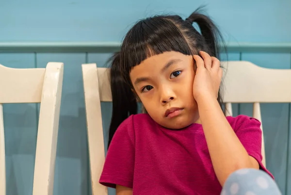 Moody Little Asian Girl Sitting Looking Camera Wooden Wall Backdrop — Stock Photo, Image