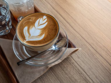 Sıcak latae ahşap trey üzerinde kahve. Ahşap masa üstü.