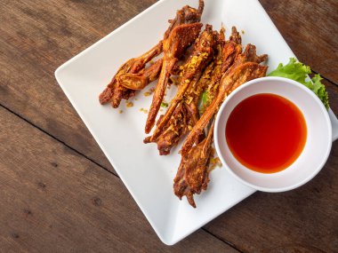 Tayland Doğu mutfağı, ördek ağzı sarımsak beyaz plateon ahşap masa ile derin yağda kızartılmış. Üstten görünüm görüntü.