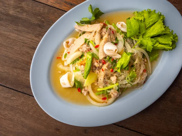 Tay gıda yum Woon Seng denilen veya mürekkep ile ekşi ve baharatlı erişte salatası. Ahşap masa üstünde yiyecek. Üstten görünüm gıda resim.