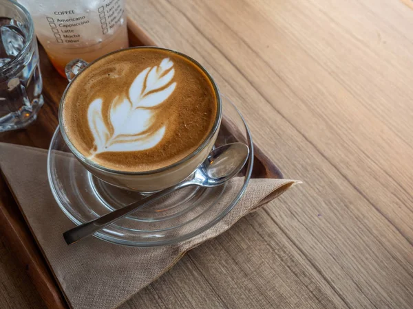 Sıcak latae ahşap trey üzerinde kahve. Ahşap masa üstü.