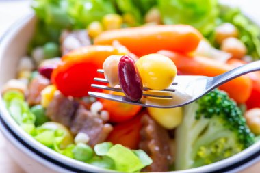 Kırmızı fasulye, fındık, Ginkgo biloba çatal üzerinde kapatın. Arka plan bulanık salatası.