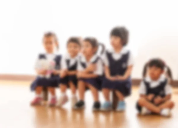 亚洲幼儿园学生连续坐着的模糊形象 — 图库照片