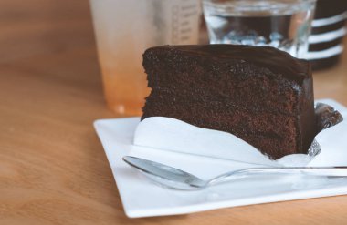 Sıcak renkli beyaz tabakta çikolatalı pasta bir parça.