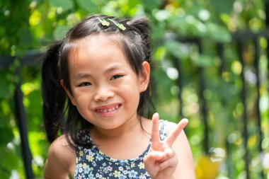 Küçük kız iki parmak gösterir