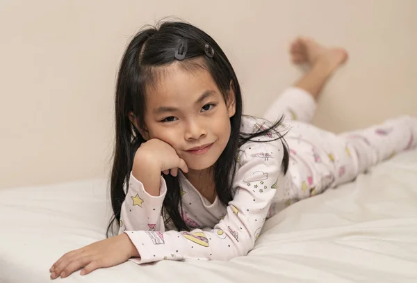stock image  little girl lying on the bed and leaning on her arm