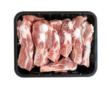 Beyaz arka planda siyah tepside organik kaburgalar. Satmak için küçük siyah tepside dizilmiş taze çiğ pirzola. Dosyada yol kırpılıyor, en üst görüntü.