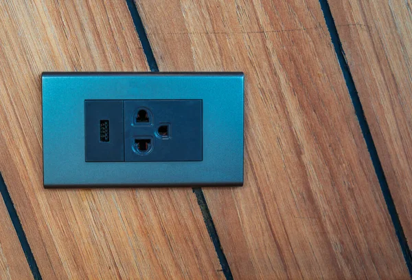 Home interior electrical outlet on strip wooden wall, modern electrical outlet with USB port charger.