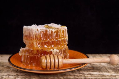 ahşap arka plan üzerinde bir tabakta peteğin tatlım