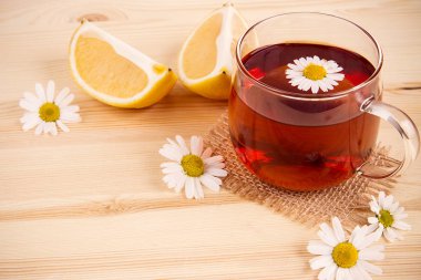 çay limon ve ahşap arka plan üzerinde papatya