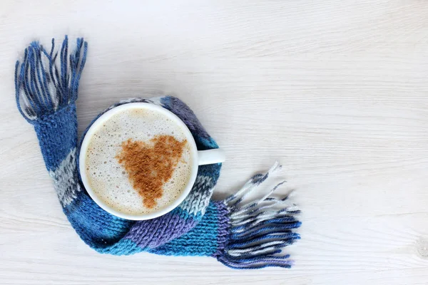 コーヒーとシナモンの心に包まれた青いスカーフ 雰囲気愛好家のために地球温暖化の象徴の赤マグカップ — ストック写真