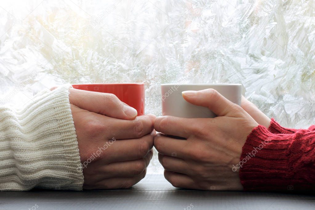 warming meeting couple in love pair on a background of frozen window with a winter pattern / share warmest feelings