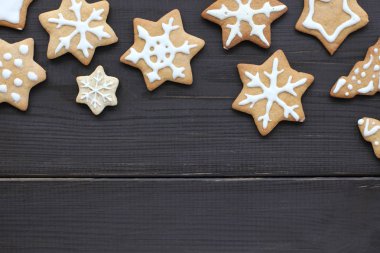 el ile yapılan figürlü gingerbread çerezleri koyu ahşap arka plan üzerinde yalan desenli / kar taneleri, kar yağışı lezzetli Noel