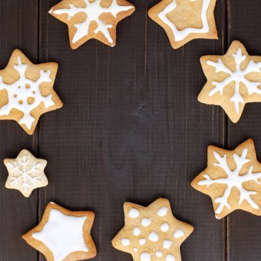 yıldızlar ve koyu ahşap arka plan üzerinde kar taneleri şeklinde çerez düz düzen / çerçeve iştah açıcı kış kar fırtınası