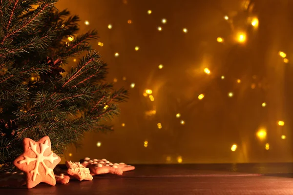 クリスマス ツリーとの背景を持つ木製のテーブルで考え出したジンジャーブレッド光花輪 新年の前にイブ — ストック写真