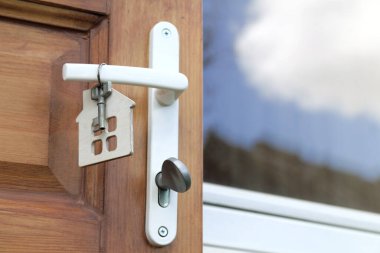 anahtar ve ev sembolü pencerenin yanındaki ön kapının sapında asılı / Konut Gayrimenkul