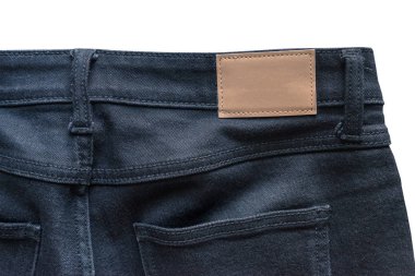 Arka kot pantolon deri kot etiketi üzerinde siyah bir kot pantolon diktim. Kırpma yolu ile beyaz arka plan üzerinde izole.