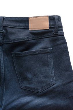 Arka kot pantolon deri kot etiketi üzerinde siyah bir kot pantolon diktim. Kırpma yolu ile beyaz arka plan üzerinde izole.