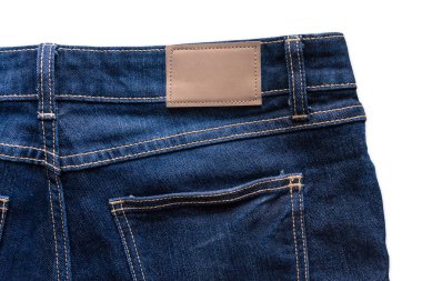 Mavi kot pantolon deri jeans etiket ile arkası kot üzerinde dikilmektedir. Kırpma yolu ile beyaz arka plan üzerinde izole.