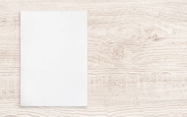 Ahşap arka plan üzerinde beyaz kağıt levha.