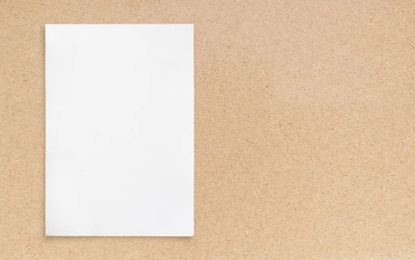 Kahverengi zemin üzerine beyaz kağıt levha.