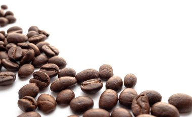 Beyaz zemin üzerine kavrulmuş kahve çekirdekleri. Yakın çekim yansıma.