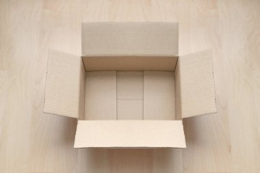 Ahşap arka planda boş dikdörtgen karton kutu. Çevrimiçi nesne arkaplanı alınıyor. Paket nesnesi gönderiliyor.