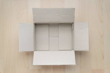 Ahşap arka planda boş dikdörtgen karton kutu. Çevrimiçi nesne arkaplanı alınıyor. Paket nesnesi gönderiliyor.