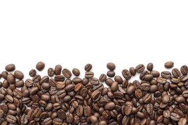 Beyaz zemin üzerine kavrulmuş kahve çekirdekleri. Yakın çekim yansıma.