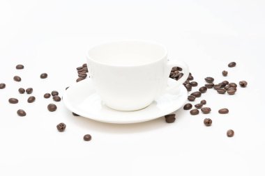 Kahve çekirdekleri ve beyaz arka plan üzerinde izole beyaz kahve fincanı.