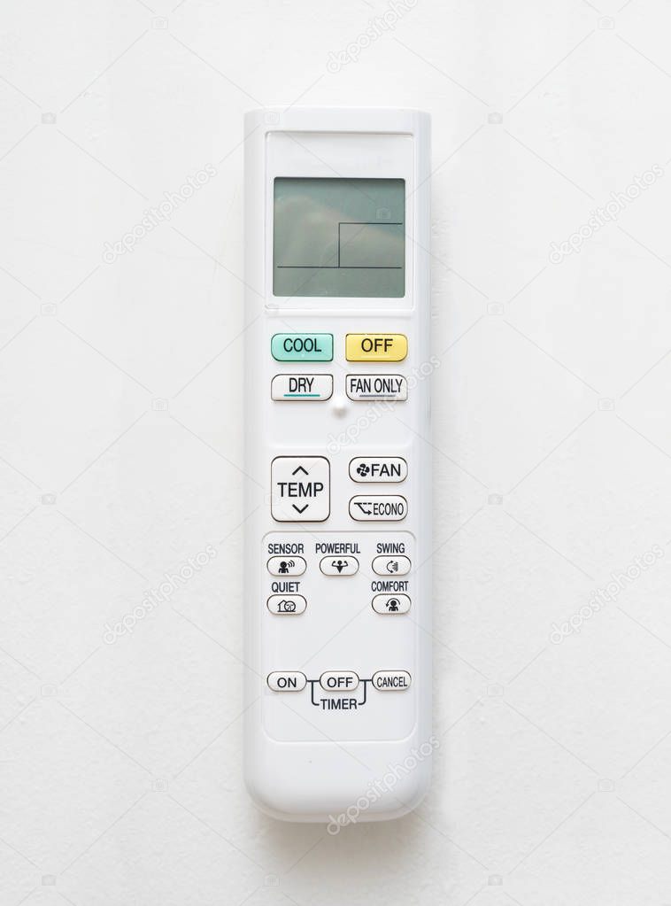 Air conditioner remote control on white concrete wall background.