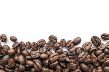 Beyaz zemin üzerine kavrulmuş kahve çekirdekleri. Yakın çekim yansıma.