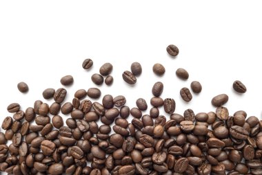 Beyaz zemin üzerine kavrulmuş kahve çekirdekleri. Yakın çekim yansıma.