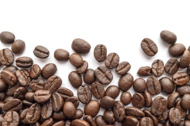 Beyaz zemin üzerine kavrulmuş kahve çekirdekleri. Yakın çekim yansıma.