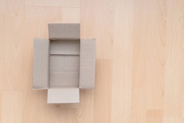 Ahşap arka planda boş dikdörtgen karton kutu. Çevrimiçi nesne arkaplanı alınıyor. Paket nesnesi gönderiliyor.