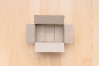 Ahşap arka planda boş dikdörtgen karton kutu. Çevrimiçi nesne arkaplanı alınıyor. Paket nesnesi gönderiliyor.