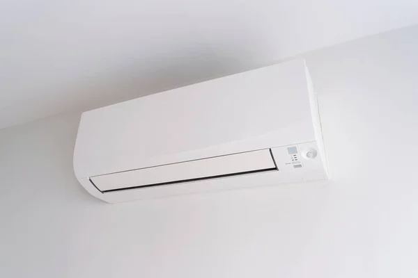 Oda boşluğunda beyaz beton duvarda klima var..